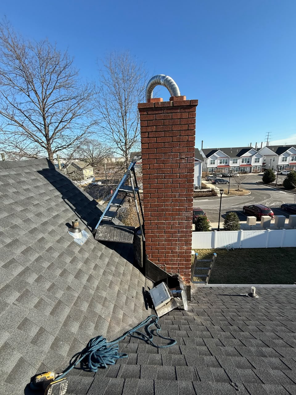 Brick chimney fitted with a stainless steel liner pipe during work on the roof