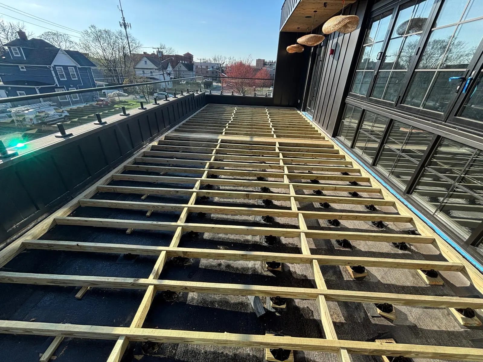 Rooftop deck framing set on pedestals over the roof membrane