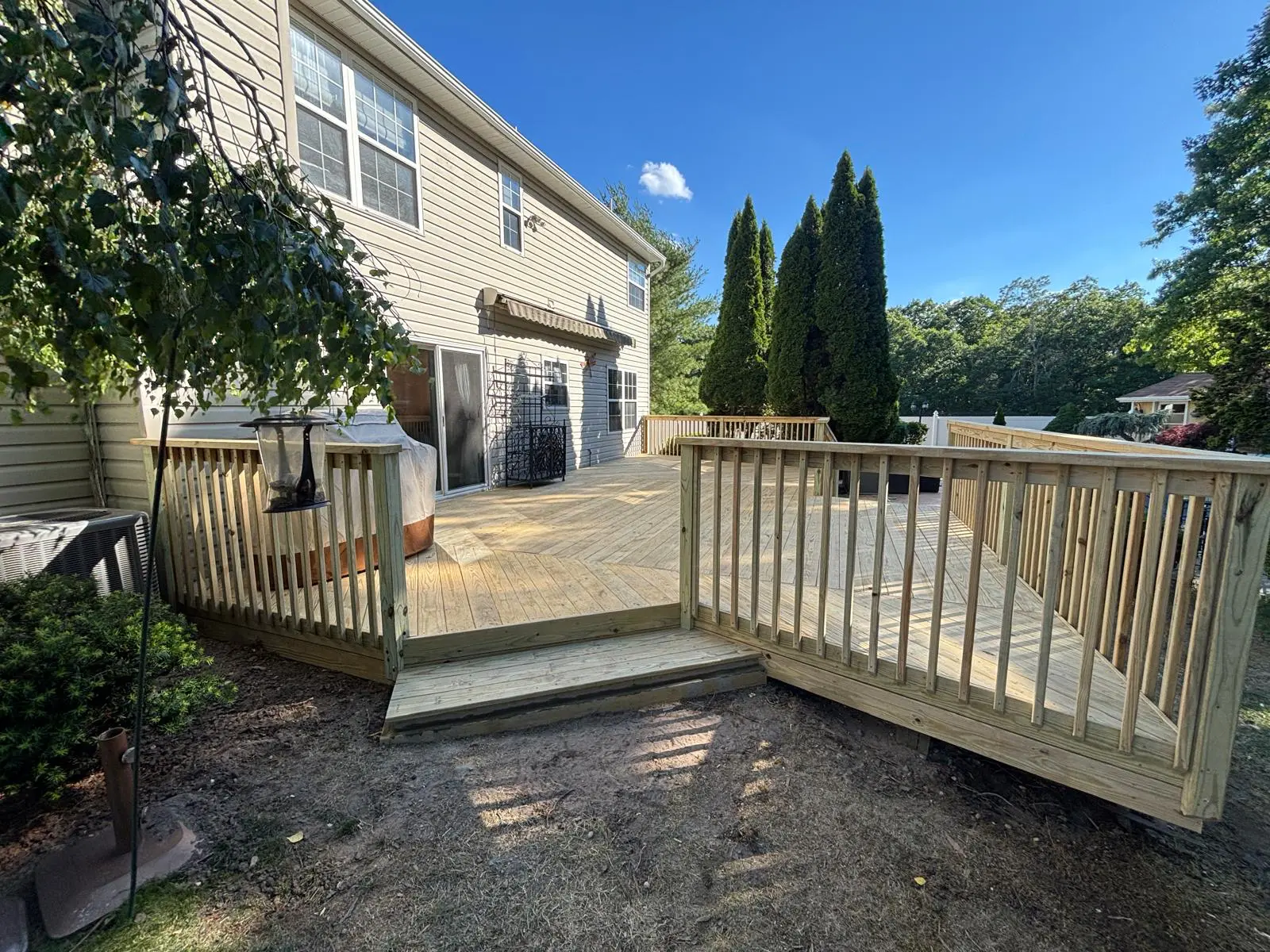 Rebuilt deck with new wood railings, refreshed surface and rebuilt stairs